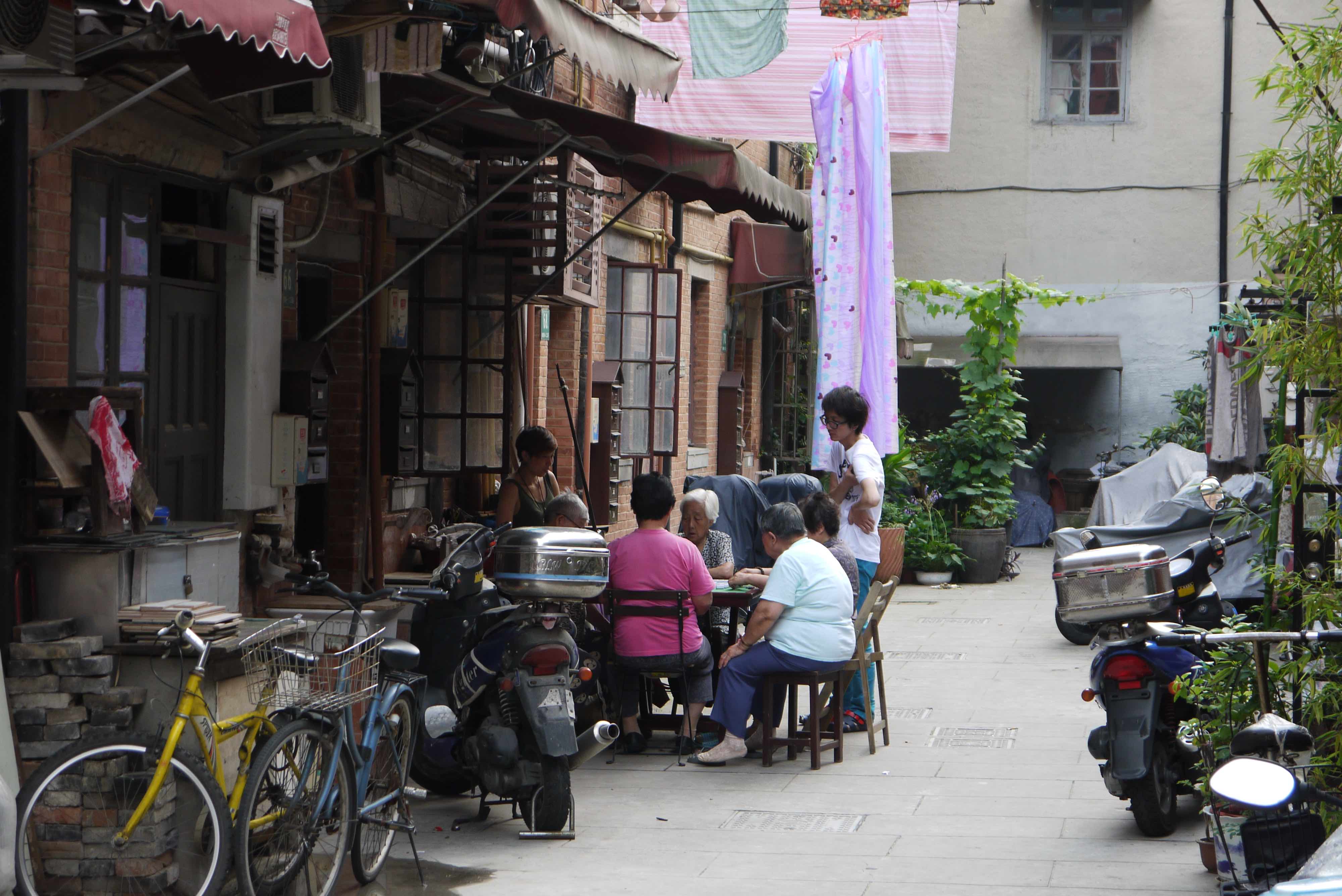 Lane as living room — cards, scooters, laundry.